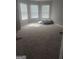 Large bedroom with carpet, multiple windows, and natural light at 1049 Homer Ln, Stockbridge, GA 30281