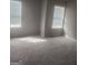 A bright, neutral-colored bedroom with carpet and sunlight shining through windows at 1049 Homer Ln, Stockbridge, GA 30281