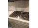Close-up of a modern stovetop with stainless steel knobs, and gray cabinets at 1049 Homer Ln, Stockbridge, GA 30281
