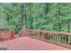 View of the wood-stained deck overlooking lush trees and greenery creating a private backyard at 165 Hidden Lake Dr, Fayetteville, GA 30215