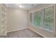 Bedroom with neutral walls, plush carpet, bright window, and white built in shelving at 165 Hidden Lake Dr, Fayetteville, GA 30215