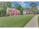 Beautifully landscaped front yard with brick home and mature trees in background at 165 Hidden Lake Dr, Fayetteville, GA 30215