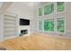 Bright living room boasts large windows, hardwood floors and fireplace with custom built-ins at 165 Hidden Lake Dr, Fayetteville, GA 30215