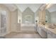 Bright primary bathroom with double vanity, tile floors, and soaking tub under a vaulted ceiling at 165 Hidden Lake Dr, Fayetteville, GA 30215