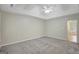 Large main bedroom with plush carpet, neutral walls, tray ceiling, and attached primary bath at 165 Hidden Lake Dr, Fayetteville, GA 30215