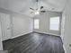 Bright bedroom with vaulted ceiling, two windows, gray walls, dark wood floors, and a ceiling fan at 3075 Lakeside Cir, Covington, GA 30016