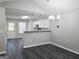 Open dining room with modern chandelier, gray walls, dark wood floors, white trim and lots of natural light at 3075 Lakeside Cir, Covington, GA 30016