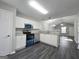 Bright kitchen with stainless steel appliances, granite countertops, white cabinets and dark floors at 3075 Lakeside Cir, Covington, GA 30016