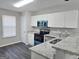 Bright kitchen with stainless steel appliances, granite countertops, white cabinets and dark floors at 3075 Lakeside Cir, Covington, GA 30016