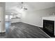 Spacious living room featuring sleek dark floors, vaulted ceiling, a cozy fireplace and an open view into the kitchen at 3075 Lakeside Cir, Covington, GA 30016