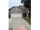 Charming two-story brick home with a two-car garage and mature landscaping at 921 Winding Down Way, Grayson, GA 30017
