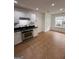 A well-lit kitchen featuring white cabinets, stainless steel appliances, and neutral floor tiles at 921 Winding Down Way, Grayson, GA 30017