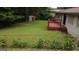 Spacious backyard with a small deck, grassy area, mature trees, and a storage shed at 503 Roy Huie Rd, Riverdale, GA 30274