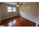 Bedroom featuring hardwood floors, a ceiling fan, and a large window, creating a cozy space at 503 Roy Huie Rd, Riverdale, GA 30274