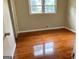 Sunlit bedroom featuring polished hardwood floors, light walls, and trim at 503 Roy Huie Rd, Riverdale, GA 30274