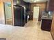 Functional kitchen with tile flooring, wood paneling, black appliances, and access to other rooms at 503 Roy Huie Rd, Riverdale, GA 30274