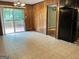 Spacious eat-in kitchen with tile flooring, wood paneling, access to outdoor deck, and black appliances at 503 Roy Huie Rd, Riverdale, GA 30274