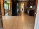 Open kitchen with tile floor, wood paneling, black appliances, and access to adjacent rooms at 503 Roy Huie Rd, Riverdale, GA 30274