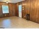 Cozy living room features wood paneling, tile flooring, and natural light from a unique glass block window at 503 Roy Huie Rd, Riverdale, GA 30274