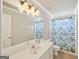 Bathroom featuring a large mirror, shower-tub combo with a blue curtain, and a white vanity at 1535 Lake Dow Rd, Mcdonough, GA 30252