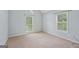 Comfortable bedroom featuring neutral colors, carpet flooring, and two windows for natural light at 1535 Lake Dow Rd, Mcdonough, GA 30252