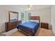 Inviting bedroom with carpet flooring, a ceiling fan, a large dresser, and two windows overlooking the yard at 1535 Lake Dow Rd, Mcdonough, GA 30252