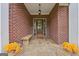 Charming front porch with brick accents, wooden bench, and decorative floral arrangements creating a cozy entrance at 1535 Lake Dow Rd, Mcdonough, GA 30252