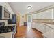 Well-lit kitchen with white cabinetry, stainless steel appliances, and hardwood flooring at 1535 Lake Dow Rd, Mcdonough, GA 30252