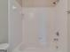 Close up of the tub and shower with tiled white walls and chrome shower head at 124 Camry Sw Ln, Grayson, GA 30017
