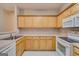 Well-lit kitchen showcasing ample counter space, light wood cabinets, and white appliances at 124 Camry Sw Ln, Grayson, GA 30017
