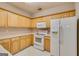 Bright kitchen featuring light wood cabinets and white appliances, including a refrigerator and oven at 124 Camry Sw Ln, Grayson, GA 30017