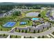 An aerial view showcasing the community amenities with a pool, tennis courts, and a scenic pond at 3525 Montebello Pkwy, Cumming, GA 30028