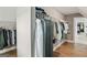Shot of a walk-in closet with hanging clothes on the wire shelving and wood flooring at 3525 Montebello Pkwy, Cumming, GA 30028