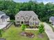 Aerial view of a brick home with a manicured lawn, garden beds, and mature trees in a desirable neighborhood at 3525 Montebello Pkwy, Cumming, GA 30028