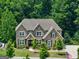 Stunning two-story brick home featuring a meticulously landscaped front yard, a welcoming entrance, and charming black shutters at 3525 Montebello Pkwy, Cumming, GA 30028