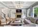 Bright living room featuring a stone fireplace, built-in shelves, coffered ceiling, and large windows at 3525 Montebello Pkwy, Cumming, GA 30028