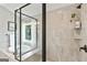 Close up of the shower with gray tile surround, matte black hardware and a corner shelf at 3525 Montebello Pkwy, Cumming, GA 30028