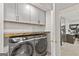 Convenient laundry room showcasing modern front-loading washer and dryer, cabinets, and wooden countertop at 4733 Julian Way, Acworth, GA 30101