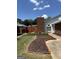 Landscaped front yard with brick edging and a walkway to the front door, shaded by trees at 135 Courtyard Ln, Fayetteville, GA 30215