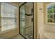 Elegant bathroom featuring a glass-enclosed shower, a window, and tile accents at 2436 Green Hollow Ct, Conyers, GA 30012