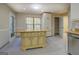 Kitchen with island, granite countertops, white cabinets, and tile flooring at 2436 Green Hollow Ct, Conyers, GA 30012