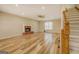 Spacious living room with wood floors, ceiling fan, a brick fireplace, and staircase access at 2436 Green Hollow Ct, Conyers, GA 30012