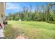 Sprawling backyard featuring lush green grass, storage shed, and bordering mature trees at 210 Jenny Ct, Grantville, GA 30220