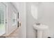 Compact half bathroom with a pedestal sink, a round mirror, and white walls at 210 Jenny Ct, Grantville, GA 30220