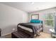 The bedroom includes ample light, a window and an ottoman at 210 Jenny Ct, Grantville, GA 30220