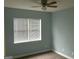A bright bedroom with a ceiling fan, neutral carpet and a window with white blinds at 165 Woodgate Cir, Fayetteville, GA 30214