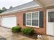 Lovely brick home featuring an attached garage, black shutters and landscaped garden at 165 Woodgate Cir, Fayetteville, GA 30214