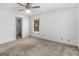 Carpeted bedroom with ceiling fan, window, and a doorway to a closet at 114 Overlook Dr, Mcdonough, GA 30252