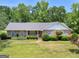 Inviting single-story home featuring a brick facade, tidy landscaping, and a serene, tree-lined backdrop at 114 Overlook Dr, Mcdonough, GA 30252