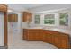 Sunlit kitchen boasts wood cabinets, white countertops and tiled floors near laundry area at 114 Overlook Dr, Mcdonough, GA 30252